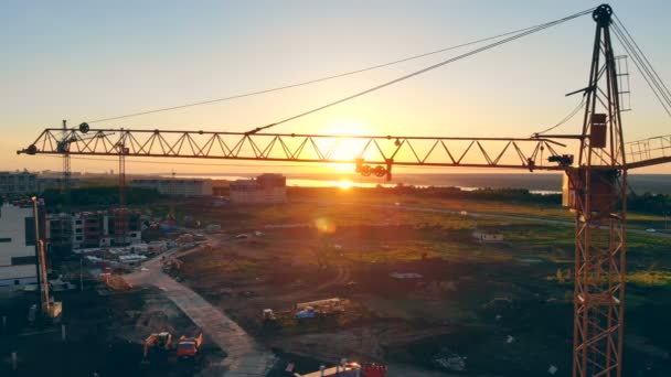 La grúa elevadora está parada en el área del edificio. Concepto inmobiliario. Sitio de construcción al atardecer . — Vídeo de stock