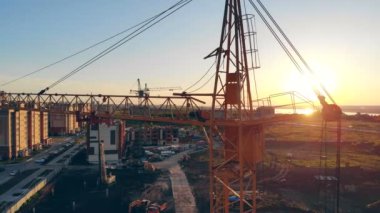 Vinç ayakta bir inşaat alanı, inşaat alanı, yukarıdaki site alanı kaldırma. İnşaat alanında günbatımı 4k.