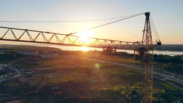 Lifting crane against the background of sunset. Construction area, building area, site area from above. — Stock Video