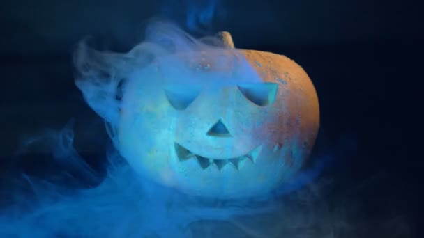 Nubes de humo emanan de una calabaza de halloween. Calabaza de Halloween en la oscuridad . — Vídeos de Stock
