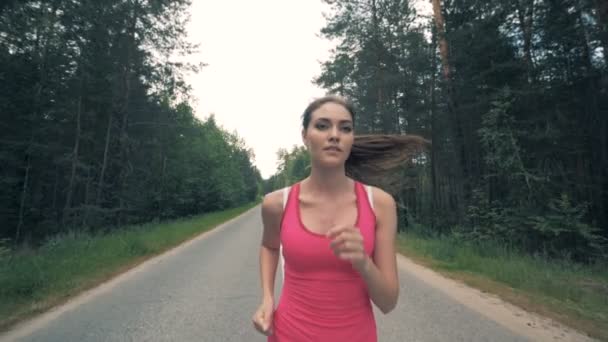 Vista frontal de uma jovem enquanto corre em câmera lenta — Vídeo de Stock