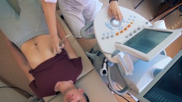 Male patient is undergoing ultrasound procedure in a medical facility — Stock Video