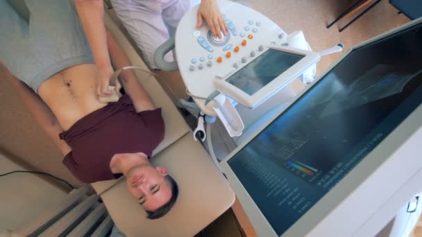 Top view of an adult man lying on a medical bed and experiencing ultrasound — Stock Footage Top view of an adult man lying on a medical bed and experiencing ultrasound Stock Video