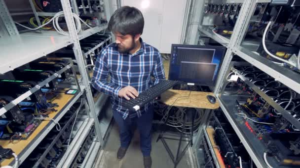 El hombre trabaja en un centro minero de criptomonedas . — Vídeos de Stock