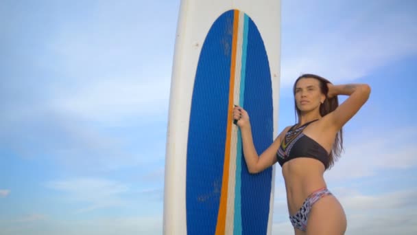 Vrouw poseren met een boord van surfen, close-up. — Stockvideo
