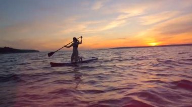 Sporcumuz bir paddleboard gidiyor.