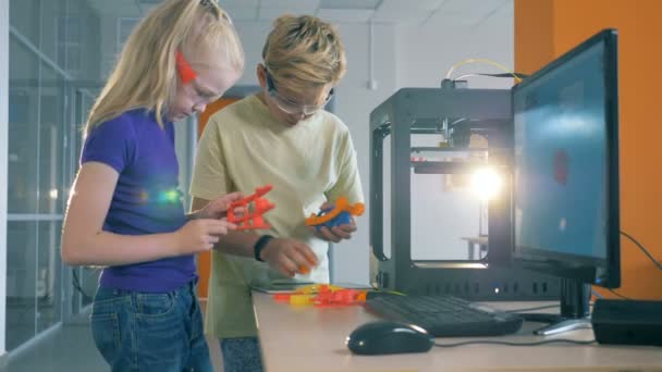 Leerlingen houden 3d gedrukte elementen in een moderne laboratorium van school. Uitvinding concept. — Stockvideo