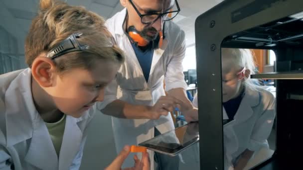 Los niños de la escuela hacen que el robot imprima en una impresora 3D . — Vídeos de Stock