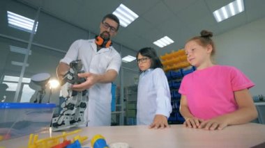Okul fen bilgisi öğretmeni robotik technolgies akıllı öğrenciler ile çalışma. Modern eğitim kavramı.