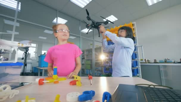 Duas crianças da escola que fixam o modelo do drone na classe moderna da escola da tecnologia. 4K . — Vídeo de Stock