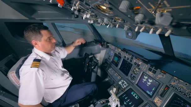 Piloto de avião masculino está regulando sua cadeira e apertando um botão enquanto decolando . — Vídeo de Stock