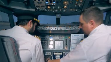 Havacılık uzmanı başka bir pilot kokpitte uçuş öncesi talimat