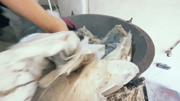 Recyklační centrum pracovník klade celulózy do kovové mlýn na drcení. 4k.