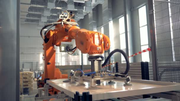 Automated robotic arm works in a factory floor. — Stock Video