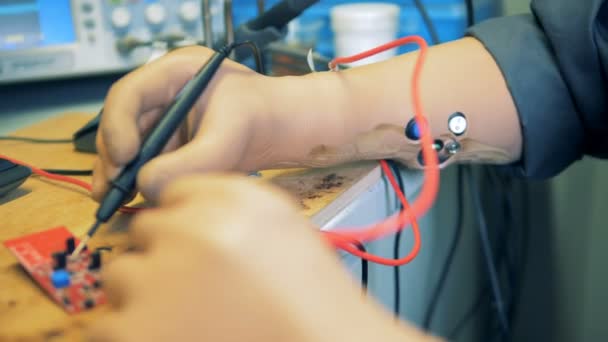 Ein behinderter Mann mit prothetischen Händen arbeitet mit elektrischen Geräten. 4k — Stockvideo