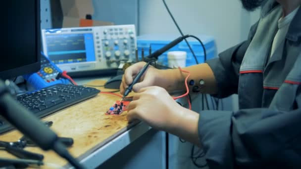 Ein behinderter Mann mit Handprothese arbeitet mit einem Voltmeter, Nahaufnahme. — Stockvideo