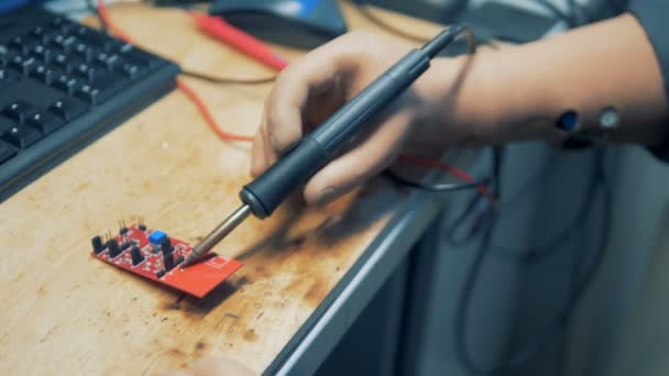 Gehandicapte persoon gebruik solderen tool op een fabriek, close-up. — Stockvideo