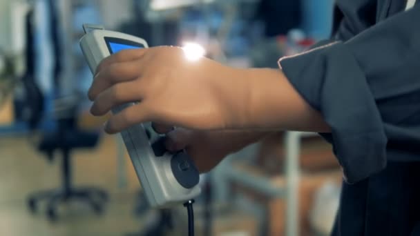 Una persona discapacitada con prótesis presiona el botón de un mando a distancia, trabajando en una planta. 4K . — Vídeo de stock