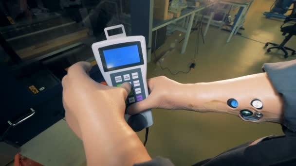 Üzemben dolgozó mesterséges kezével tartja a távirányító, közelről. — Stock videók