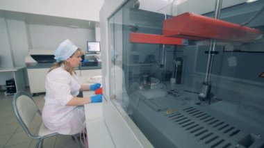 Biyokimyasal analiz örnekleri test ediyor ve bir kadın işçi işlemi denetleme