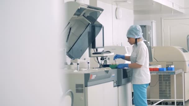 Geautomatiseerde laboratoriumapparatuur met werknemers van een productie van medicijnen. — Stockvideo