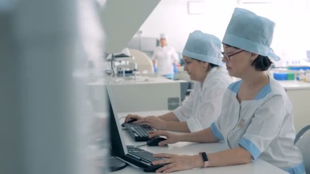 Especialistas de laboratorio trabajando con línea de fabricación farmacéutica . — Vídeo de stock