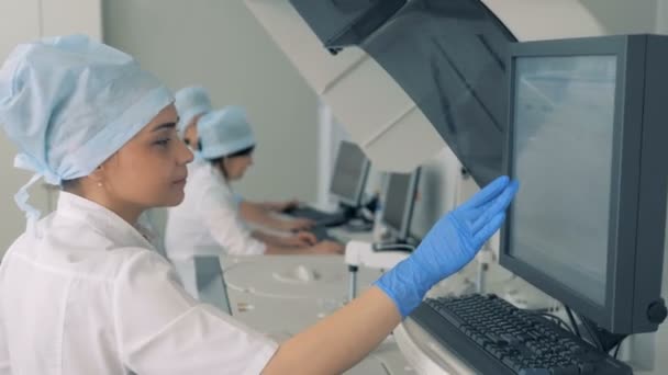 Jovencita está trabajando con equipos electrónicos de laboratorio — Vídeos de Stock