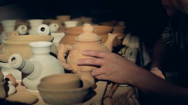 Un operaio ceramiche controlla vaso di argilla, toccandosi il labbro . — Video Stock