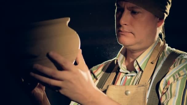 Un vasaio controlla un vaso essiccato, tenendo in mano il vaso di argilla, da vicino . — Video Stock