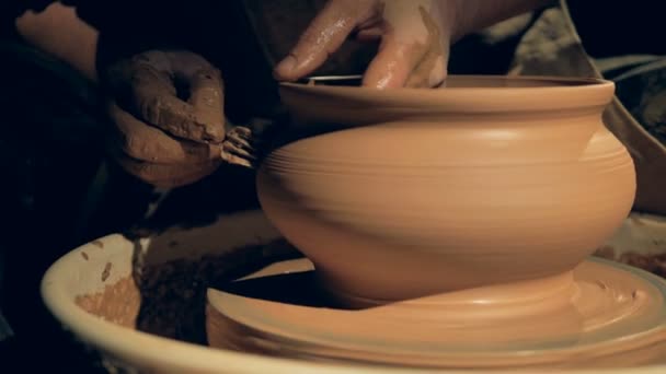 Um artesão moldando um vaso com um garfo, de perto . — Vídeo de Stock