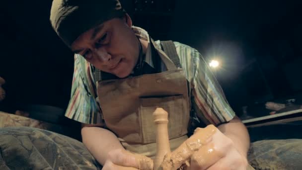 Een potter werkt met speciale apparatuur, close-up. Een man maakt een vaas van klei, vormgeving het op een speciale wiel. — Stockvideo