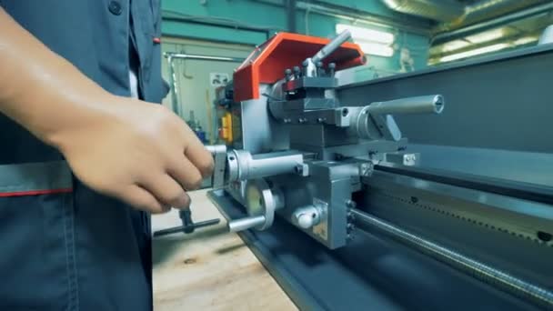 Close up of a metal lathe regulated by a factory worker with prosthetic hands — Stock Video