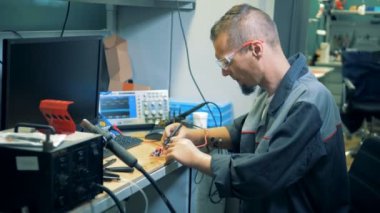 İşçi ile protez eller bir atölye bir devre lehimleme