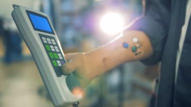 İşçiler protez eller tarafından düzenlenmiş bir freze makinesi için bir uzaktan kumanda, yakın çekim