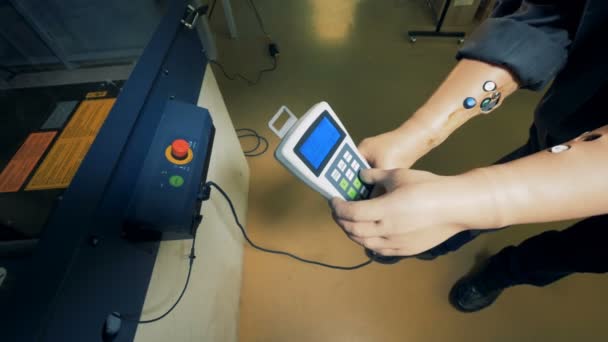 Fresadora está sendo regulada com um controle remoto em mãos protéticas dos trabalhadores — Vídeo de Stock