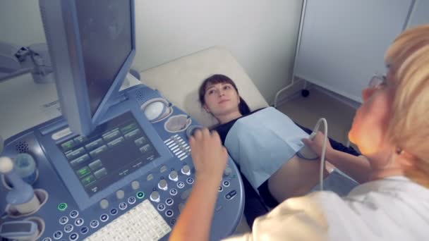 Ženské gynekolog provádí ultrazvuk procedury na těhotnou ženu. Lékařské ultrazvukové vyšetření. — Stock video