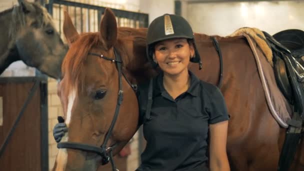 Žena se na kameru, stojící s koněm, usmívá se zblízka. Koncept lidské a zvířecí láska. — Stock video