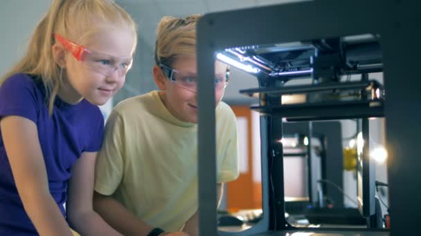 Un niño y una niña están entusiasmados con el curso de un experimento tecnológico — Vídeos de Stock