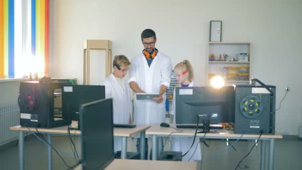 Onderzoek werknemer vertoont iets op zijn tablet pc aan de kinderen — Stockvideo