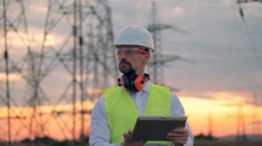 Elektrikçi işçi tablet yakınındaki güç hattı ile.