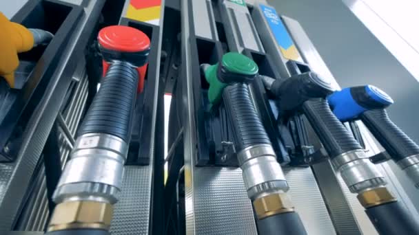 One man uses a fuelling equipment at a gas station, taking a nozzle. 4K. — Stock Video