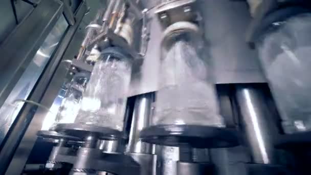 Оборудование завода заполнение много бутылок, вид снизу . — стоковое видео
