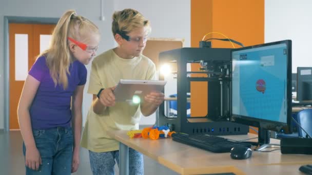 Corso di stampa 3D è sempre controllato da due bambini da un computer tablet — Video Stock