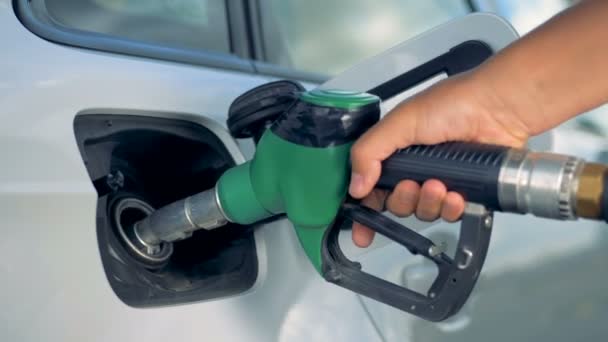 A man puts a nozzle in a car tank, close up. — Stock Video