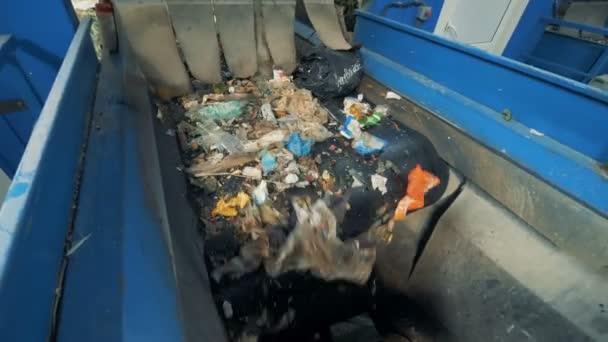 Veel afval valt van een transportband naar een ander in een recycling fabriek. 4k. — Stockvideo