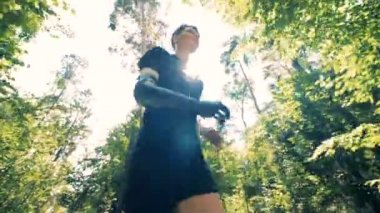 Genç cyborg kumsalda ormandaki özel yapay elini giyen adam. 4k.