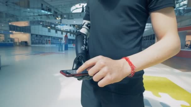 Mänsklig cyborg med en hand protes använder smartphone. — Stockvideo