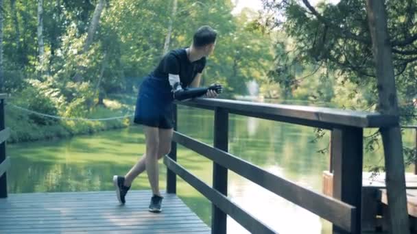 Інвалід з протезом стоїть в парку . — стокове відео