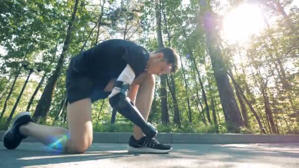 Un hombre discapacitado comienza a correr, vista lateral. brazo cyborg robótico futurista en un humano . — Vídeos de Stock