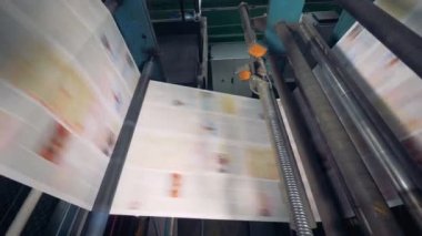 Tipografi ekipman çalışmalarında, yakın çekim. Yaprak kağıt hızla bir konveyör fabrikasında devam et..